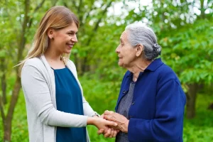 Caregiver walking outdoors with an older woman