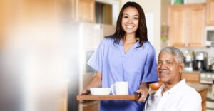 Caregiver supporting an older woman at home