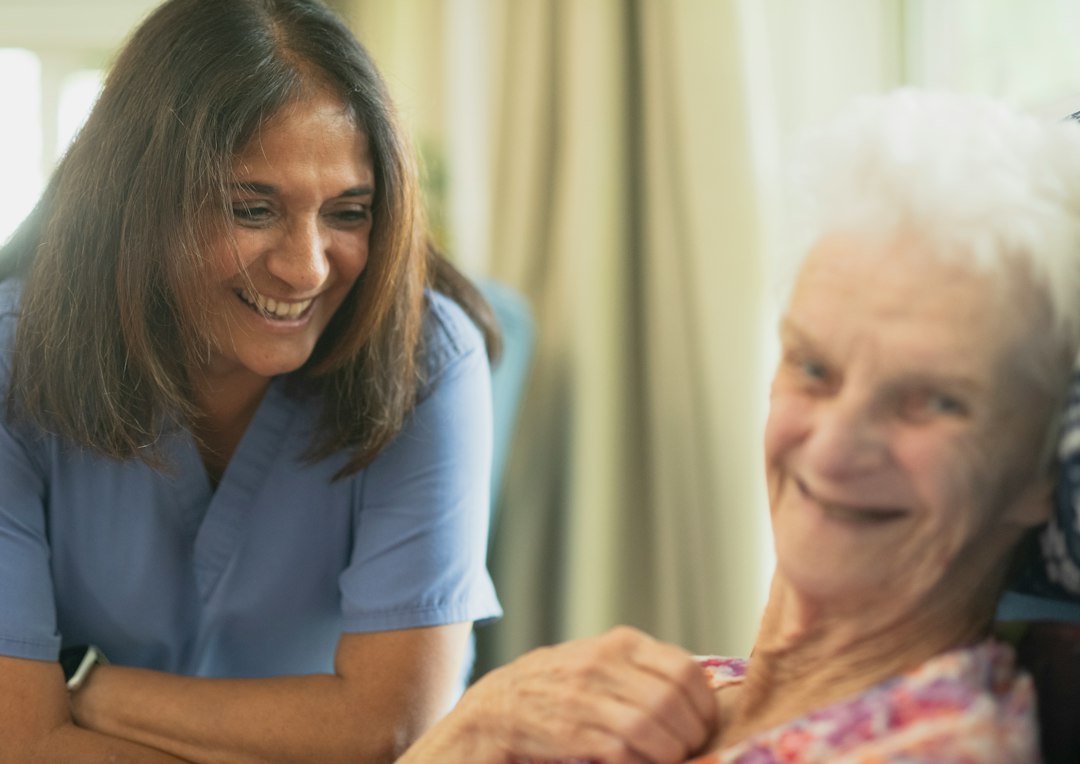 Caregiver smiling with an older client at home